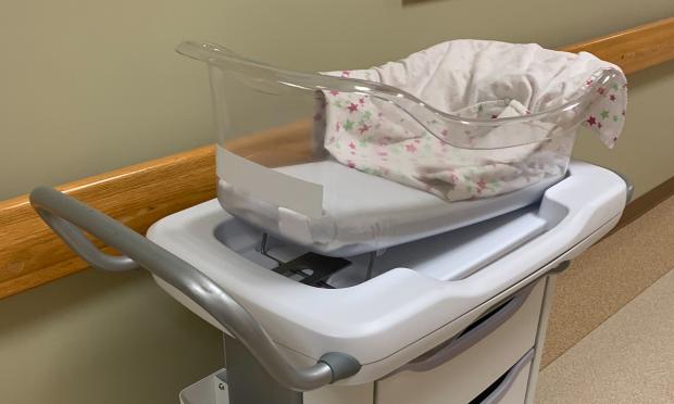 An empty bassinet in a hospital setting.