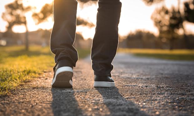 A knee-down shot of a person walking away from the camera.